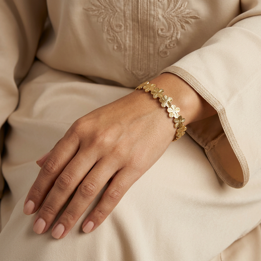 Hand-focused studio photo wearing the flower bangle with an elegant champagne sleeve