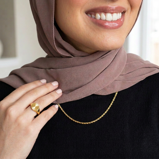 Hijabi model wearing the thin gold rope necklace and Starburst Signet Ring