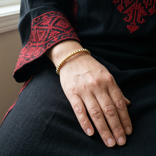 Natural square wrist close-up with the Dainty Beaded Cuff and a Palestinian thobe