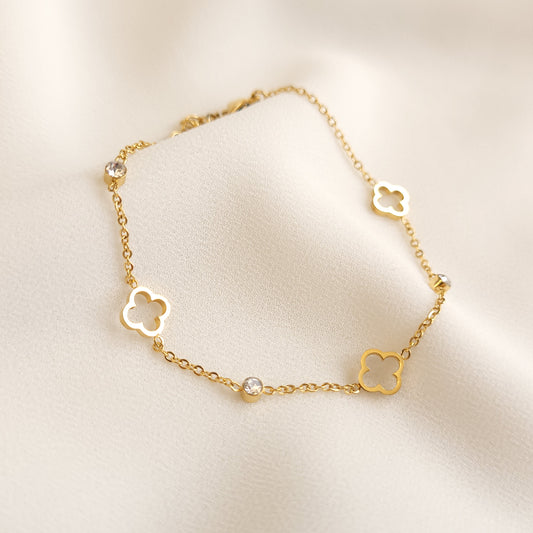 Dainty Clover Bracelet in gold tone, featuring three open clover charms alternating with round clear stones.