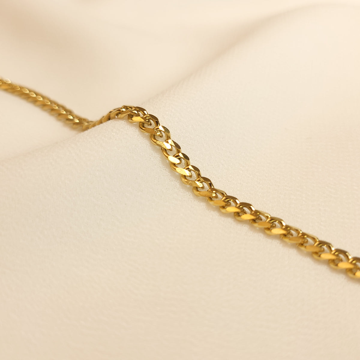 Dainty Cuban Chain Bracelet close-up showing the flattened, interlocking gold-tone links.