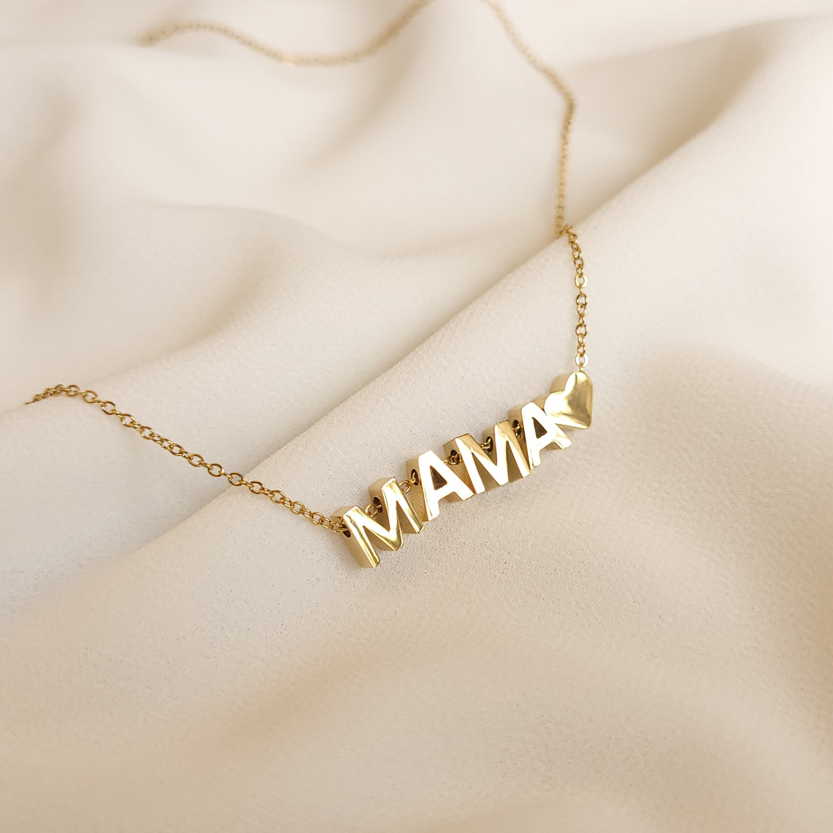 Letter Add-On MAMA and heart charms viewed at an angle, showing their polished reflective surfaces.