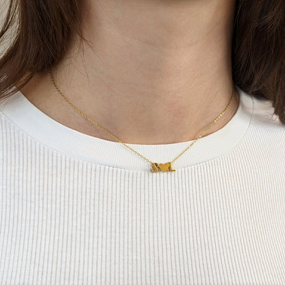Letter Add-On S and L initials with a heart between them, shown worn at the neckline of a white ribbed top.