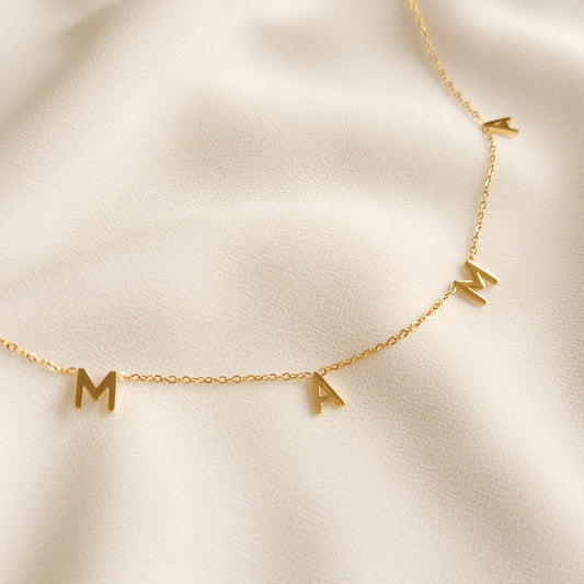 Mama Letter Necklace featuring four gold-tone letter charms spelling MAMA spaced along a delicate chain.

