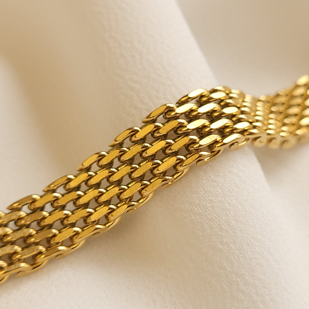 Mesh Belt Bracelet close-up showing rows of tightly interwoven, polished gold-tone links.