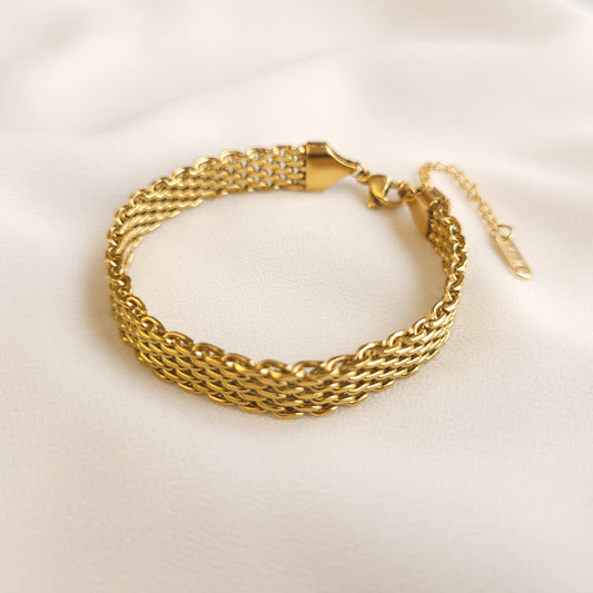 Mesh Belt Bracelet in gold tone arranged in a loop, showing its woven links and adjustable extension chain.
