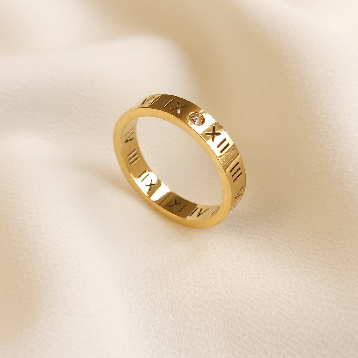 Roman Numeral Band Ring in gold tone, displayed upright to show the engraved numerals and round clear stone accents.