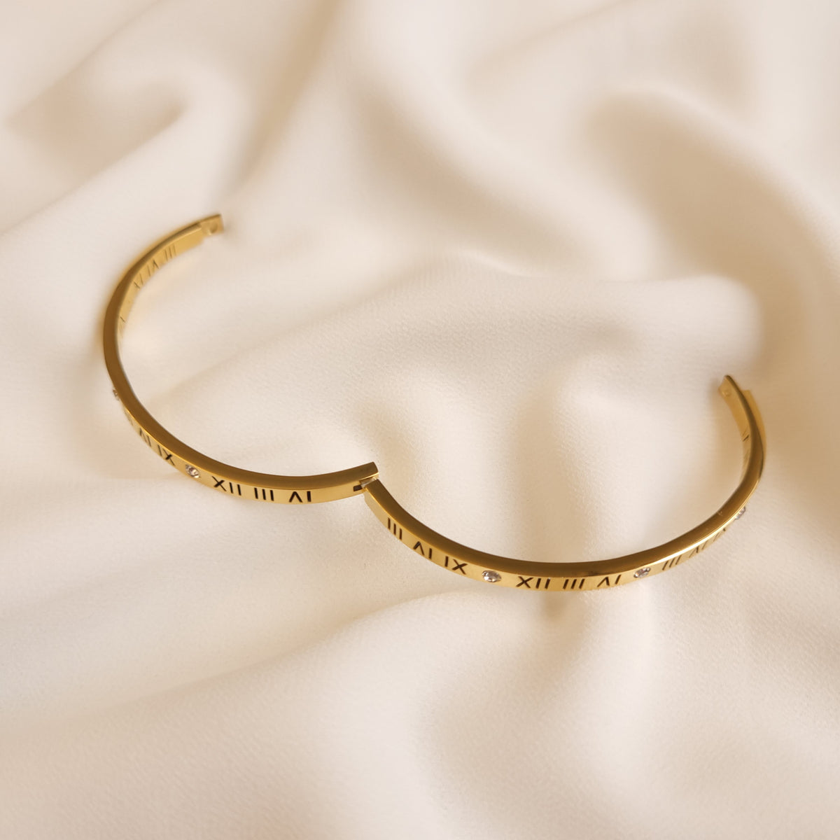 Roman Numeral Bangle shown open, revealing the hinged band and engraved numeral details.