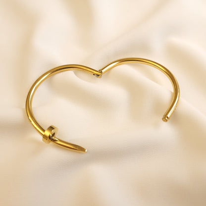 Twisted Nail Bangle shown open, revealing the hinged design and nail-shaped ends.